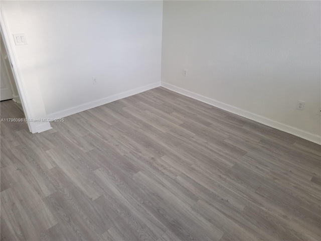 empty room featuring baseboards and wood finished floors