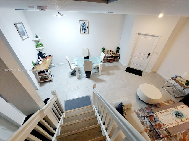 interior space with light tile patterned floors, baseboards, and stairs