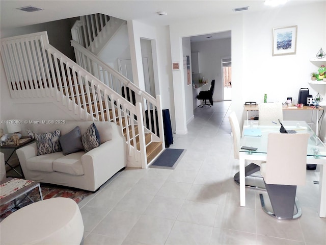 tiled living room with stairs and visible vents