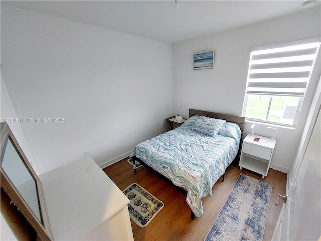 bedroom with baseboards and wood finished floors