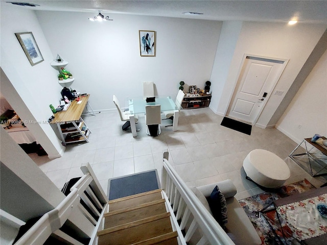 interior space featuring baseboards, tile patterned floors, and stairway