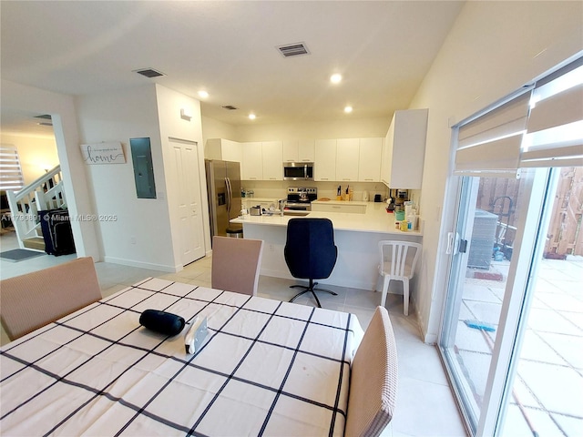 kitchen with light countertops, stainless steel appliances, visible vents, and electric panel