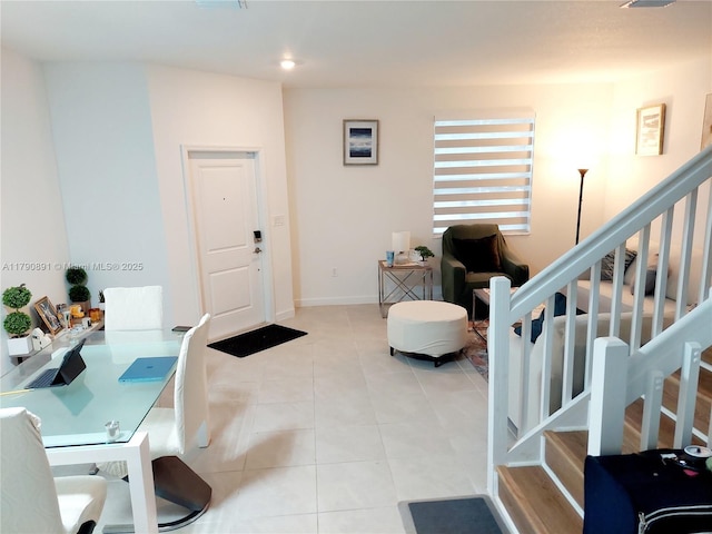 entrance foyer featuring baseboards, stairs, and light tile patterned flooring