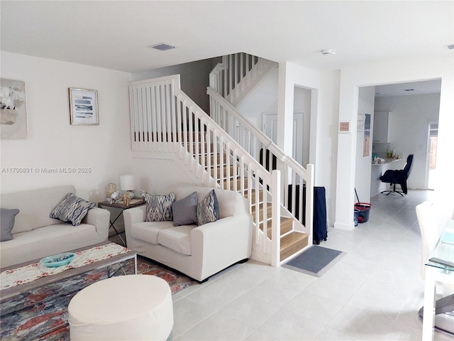 tiled living room with visible vents and stairway