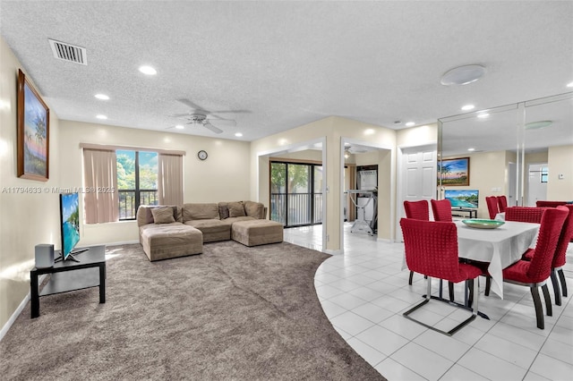 living room with visible vents, a textured ceiling, ceiling fan, and a healthy amount of sunlight