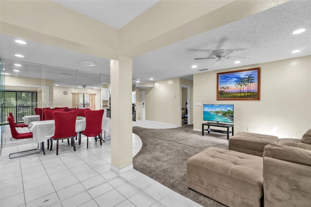 carpeted living area with a ceiling fan, visible vents, tile patterned flooring, baseboards, and recessed lighting