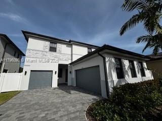 view of front of property featuring a garage, stucco siding, and decorative driveway
