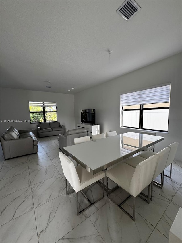 4409 SW 173rd Ave, Miramar, FL 33029 - dining area featuring light marble finish flooring and a textured ceiling