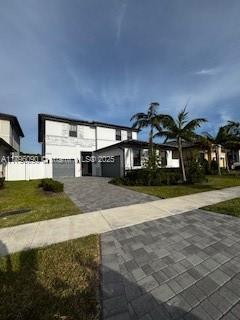 view of front facade featuring an attached garage and decorative driveway