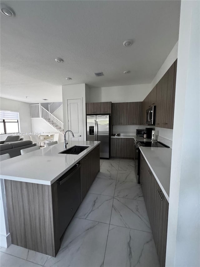 4409 SW 173rd Ave, Miramar, FL 33029 - kitchen with stainless steel appliances, modern cabinets, a sink, light marble finish floors, and light countertops