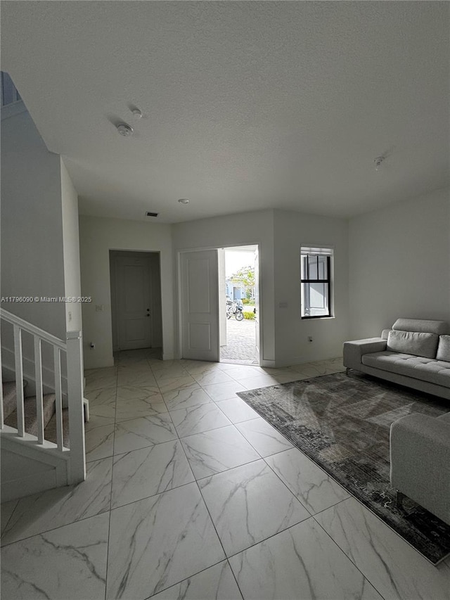 4409 SW 173rd Ave, Miramar, FL 33029 - foyer entrance with light marble finish floors, stairway, and a textured ceiling