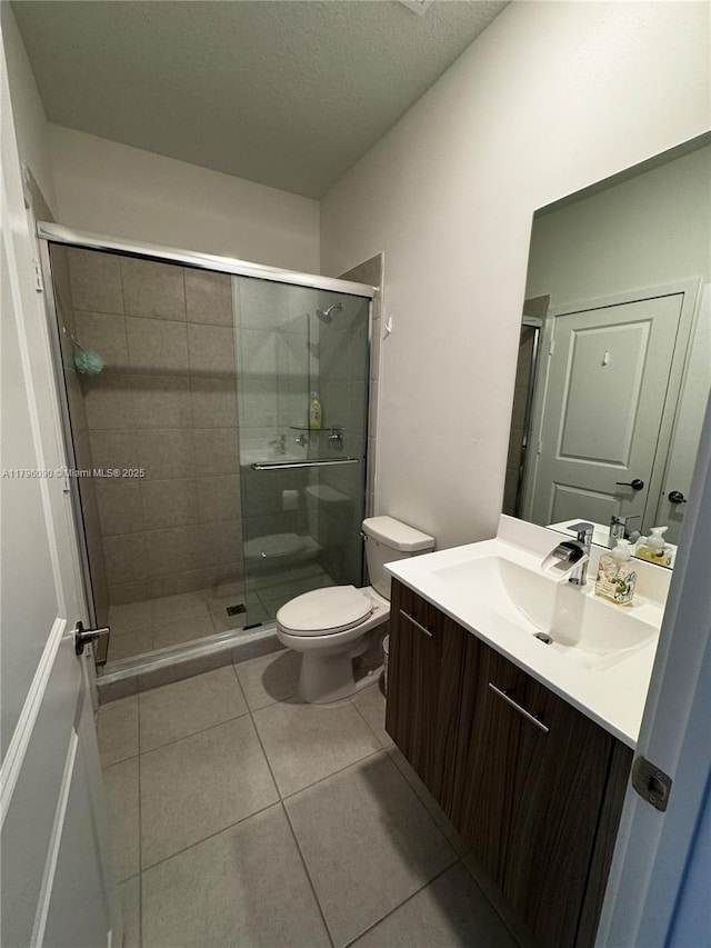 4409 SW 173rd Ave, Miramar, FL 33029 - bathroom featuring toilet, tile patterned floors, a shower stall, vanity, and a textured ceiling