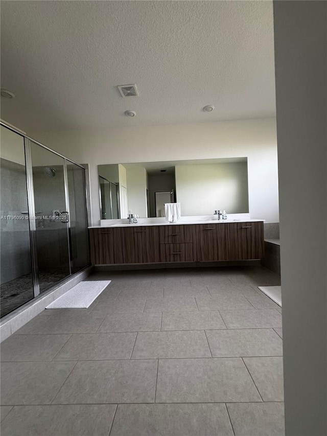 4409 SW 173rd Ave, Miramar, FL 33029 - full bathroom featuring a stall shower, tile patterned floors, double vanity, and a textured ceiling