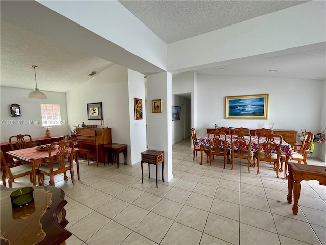 dining space with visible vents, a textured ceiling, and light tile patterned floors