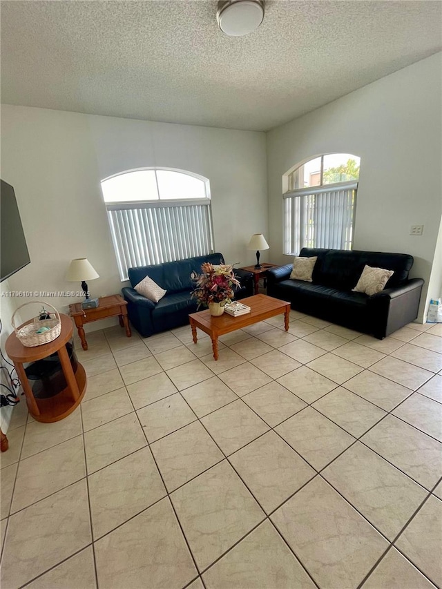 living room with a textured ceiling and light tile patterned flooring
