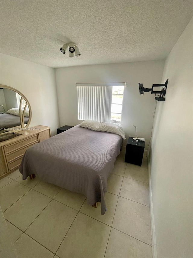bedroom featuring a textured ceiling and light tile patterned floors