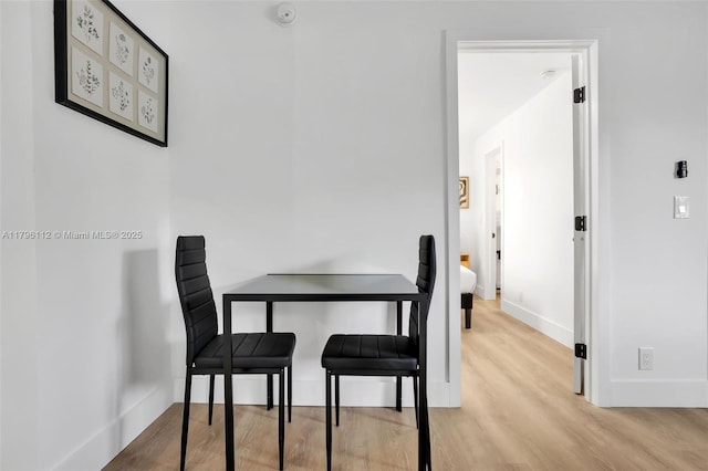 dining area with baseboards and wood finished floors