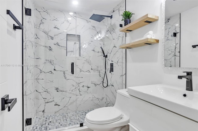 bathroom featuring a marble finish shower, vanity, and toilet