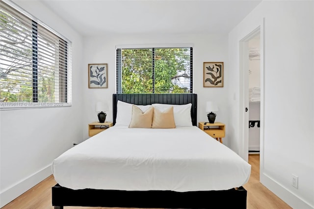 bedroom featuring baseboards and light wood-style flooring