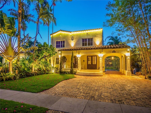 1229 Sorolla Ave, Coral Gables, FL 33134 - mediterranean / spanish home with stucco siding, covered porch, a tile roof, and a front yard
