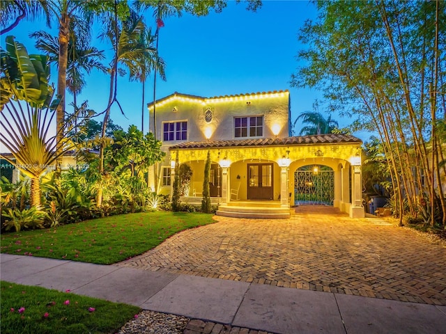 1229 Sorolla Ave, Coral Gables, FL 33134 - mediterranean / spanish home with stucco siding, covered porch, a front yard, a tiled roof, and driveway