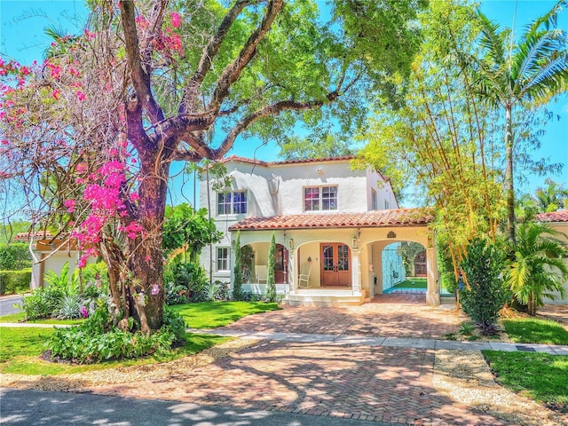 1229 Sorolla Ave, Coral Gables, FL 33134 - mediterranean / spanish house with covered porch, a tile roof, and stucco siding