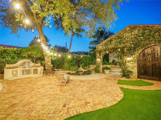 1229 Sorolla Ave, Coral Gables, FL 33134 - yard at night featuring exterior kitchen and a patio area