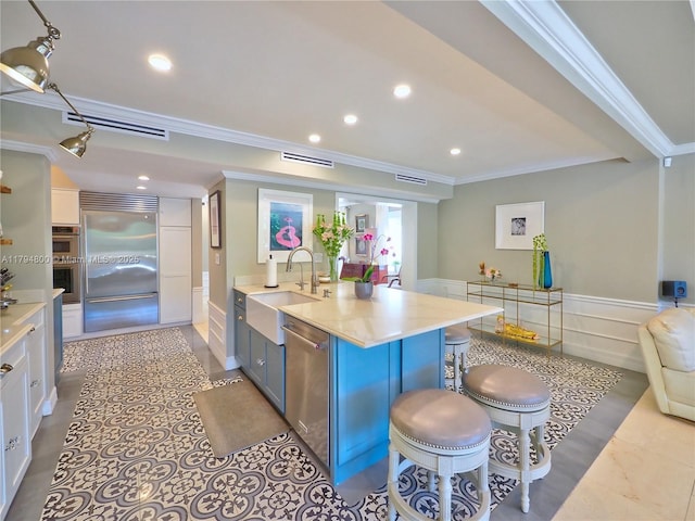 1229 Sorolla Ave, Coral Gables, FL 33134 - kitchen with appliances with stainless steel finishes, a sink, crown molding, a kitchen breakfast bar, and wainscoting