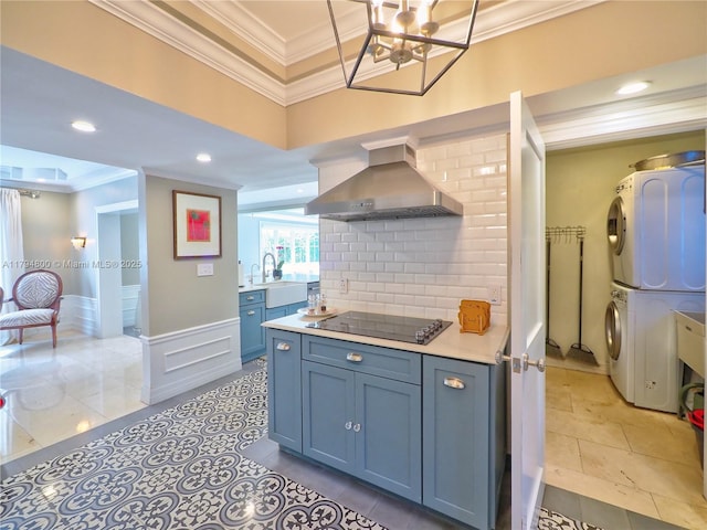 1229 Sorolla Ave, Coral Gables, FL 33134 - kitchen with stacked washer / dryer, range hood, crown molding, black electric stovetop, and light countertops
