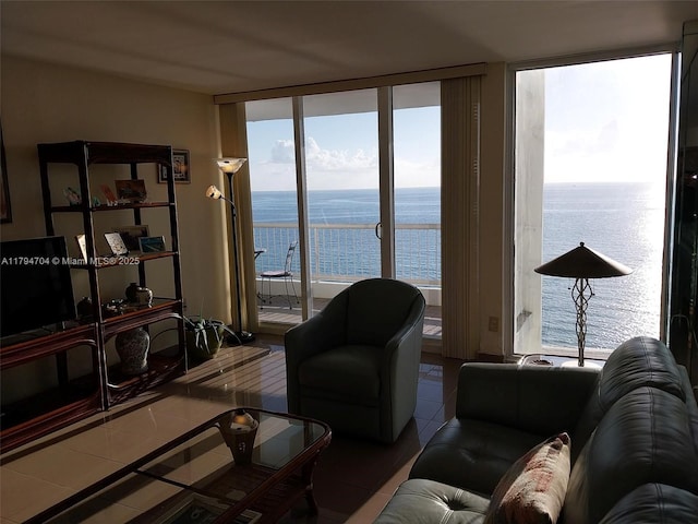 tiled living room featuring a water view and floor to ceiling windows