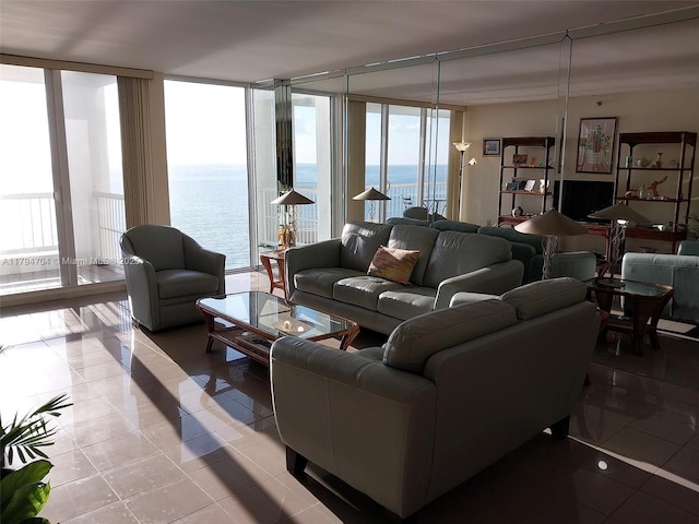 living area with light tile patterned floors, a water view, and plenty of natural light