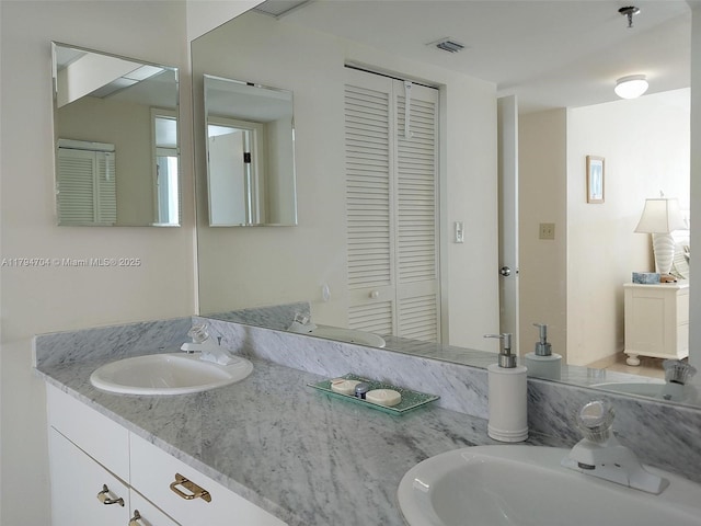 full bath with a closet, a sink, and visible vents