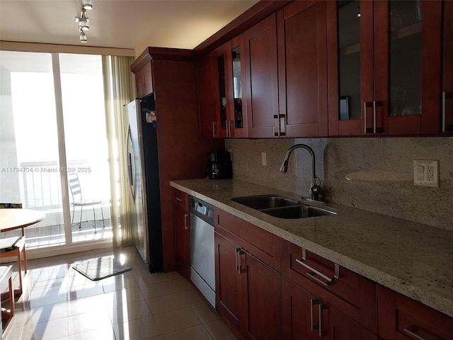 kitchen featuring a sink, glass insert cabinets, backsplash, and stainless steel appliances