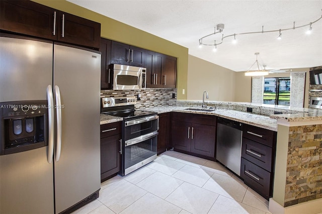 kitchen with a sink, appliances with stainless steel finishes, tasteful backsplash, and light stone countertops