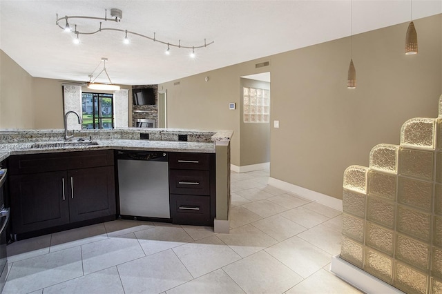 kitchen featuring stainless steel dishwasher, light stone countertops, visible vents, and a sink