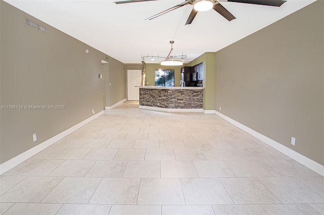 unfurnished room with light tile patterned floors, baseboards, ceiling fan, and visible vents