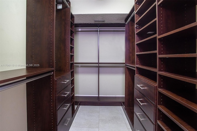 walk in closet with light tile patterned flooring