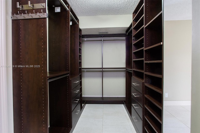 walk in closet with tile patterned floors