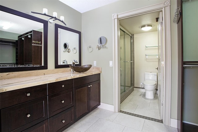 full bath with vanity, toilet, baseboards, tile patterned floors, and a stall shower