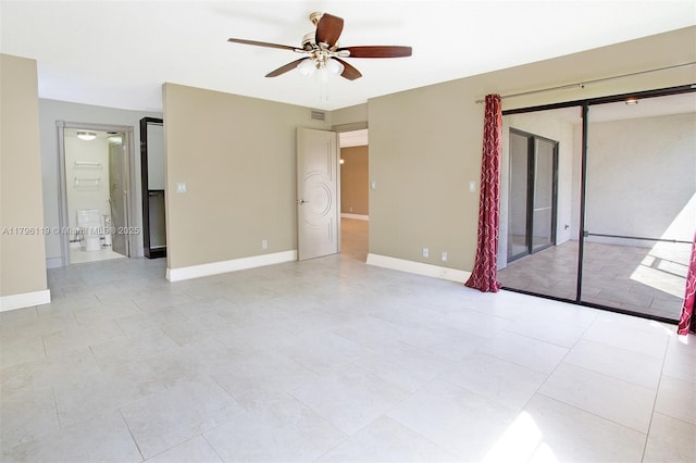 spare room with ceiling fan, visible vents, and baseboards