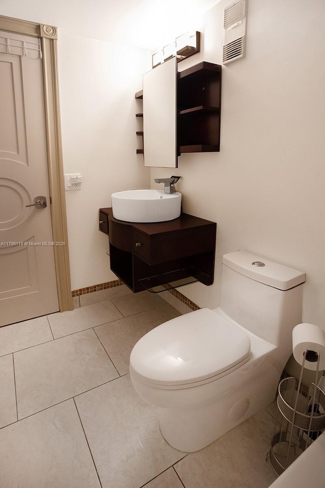 bathroom with toilet, visible vents, tile patterned flooring, and vanity