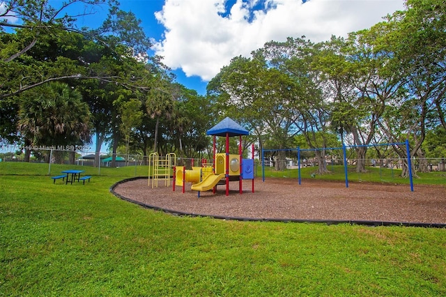 community play area featuring a lawn and fence