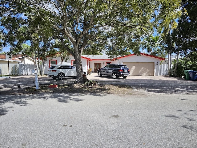 view of front of house with fence, driveway, and a garage