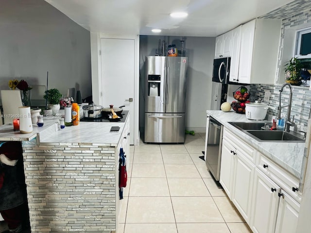 kitchen featuring white cabinets, appliances with stainless steel finishes, a sink, light countertops, and light tile patterned floors