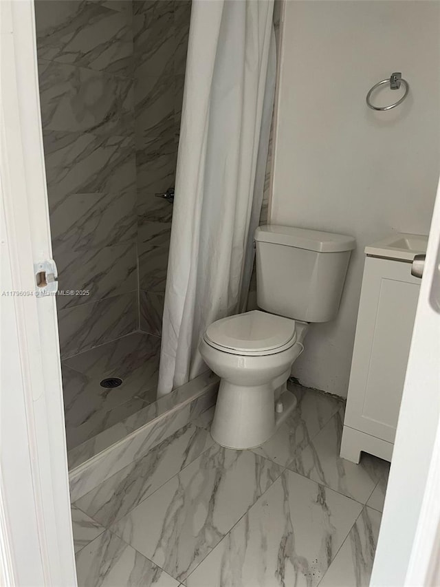 bathroom with toilet, a shower stall, marble finish floor, and vanity