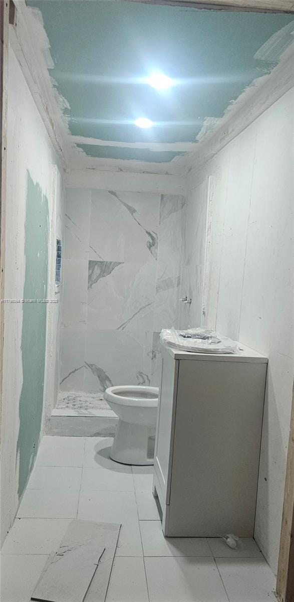 bathroom featuring vanity, toilet, and a shower stall