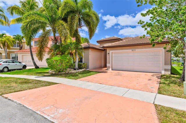 18271 SW 27th St, Miramar, FL 33029 - mediterranean / spanish-style home with a tile roof, stucco siding, a garage, and concrete driveway