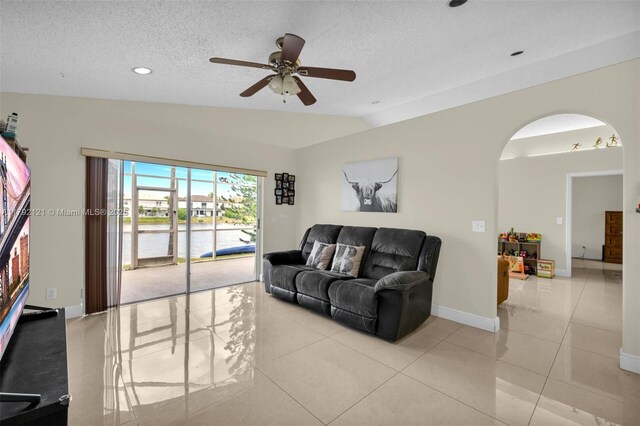 18271 SW 27th St, Miramar, FL 33029 - living room with vaulted ceiling, arched walkways, ceiling fan, light tile patterned floors, and baseboards