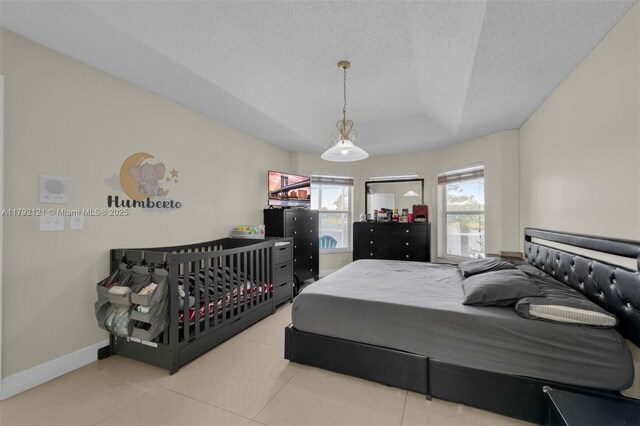 18271 SW 27th St, Miramar, FL 33029 - bedroom featuring tile patterned flooring, baseboards, a tray ceiling, and a textured ceiling