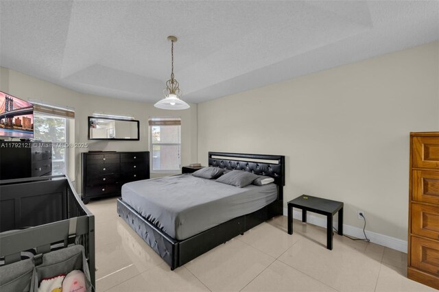 18271 SW 27th St, Miramar, FL 33029 - tiled bedroom featuring multiple windows, a raised ceiling, baseboards, and a textured ceiling